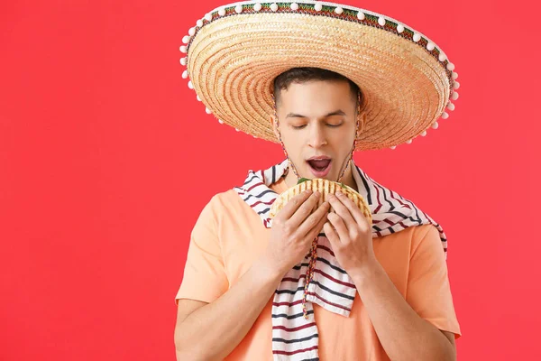 Young Mexican Man Eating Tasty Quesadilla Color Background — Stock Photo, Image