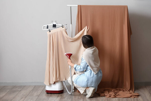 Female stylist preparing clothes for shooting in photo studio