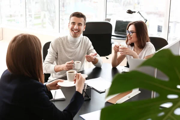 Business colleagues drinking coffee in office