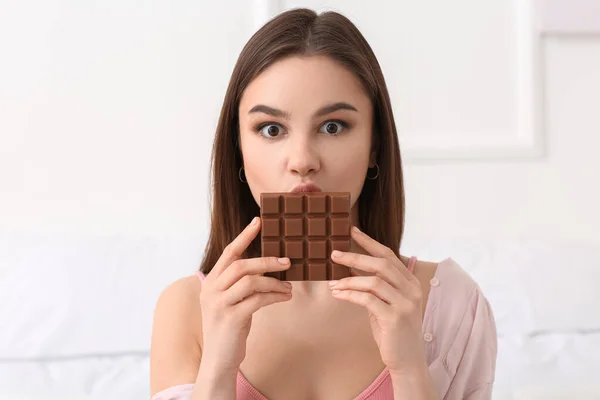 Beautiful Young Woman Eating Tasty Chocolate Home — Stock Photo, Image