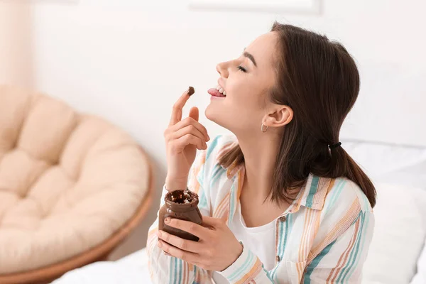 Beautiful Young Woman Eating Tasty Chocolate Paste Home — Stock Photo, Image