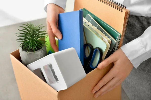 Fired female worker with personal things, closeup