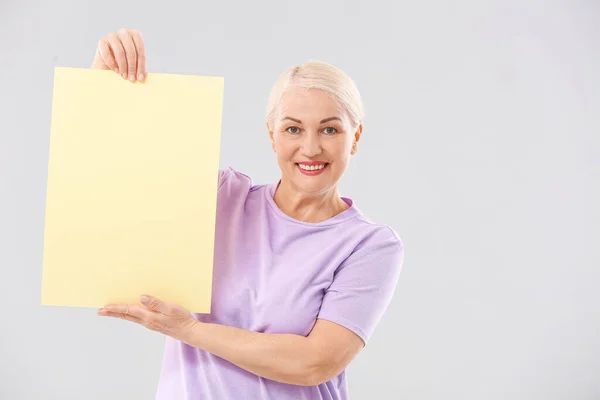 Mature Woman Blank Paper Sheet Light Background — Stock Photo, Image