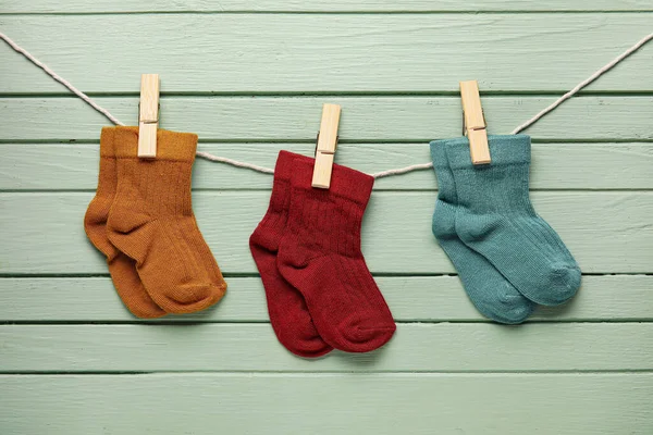 Diferentes Calcetines Bebé Colgando Cuerda Contra Fondo Madera —  Fotos de Stock