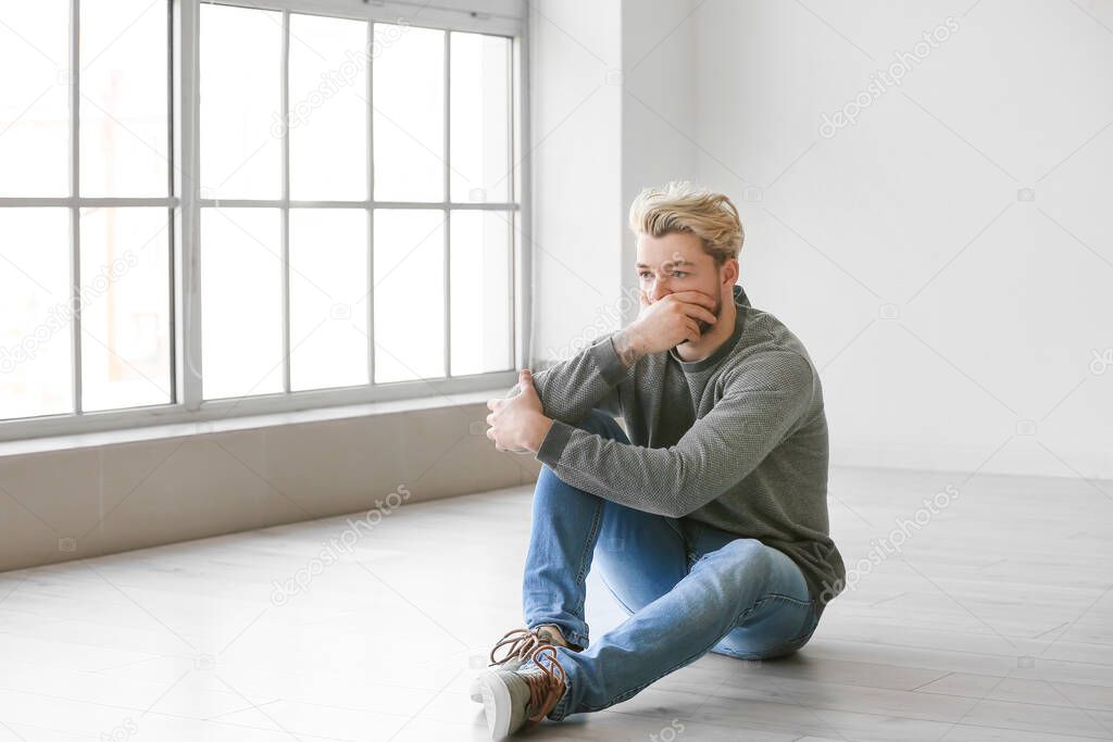 Depressed young man in empty room