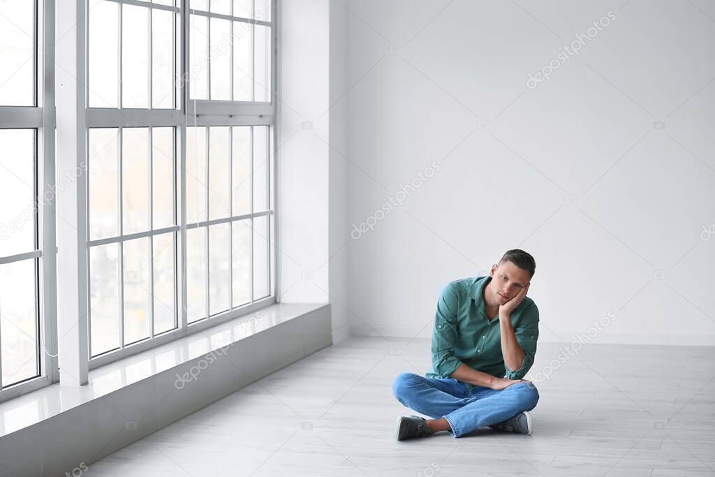 Depressed young man in empty room