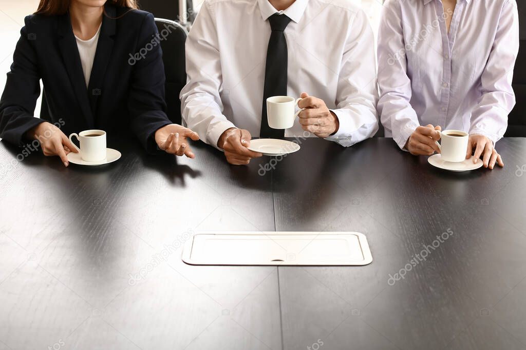 Business colleagues drinking coffee in office