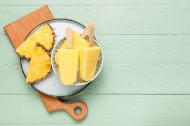 Renkli ahşap arka planda lezzetli ananaslı dondurma kasesi.