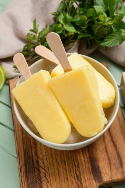 Renkli ahşap arka planda lezzetli ananaslı dondurma kasesi.