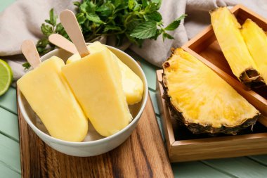 Renkli ahşap arka planda lezzetli ananaslı dondurma kasesi.