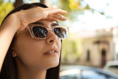 Dışarıda şık güneş gözlüğü takan genç bir kadın.