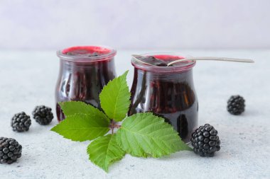 Arka planda lezzetli böğürtlen reçeli kavanozları