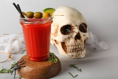 Cadılar Bayramı için hafif arka planda hazırlanmış bir bardak lezzetli Bloody Mary kokteyli.