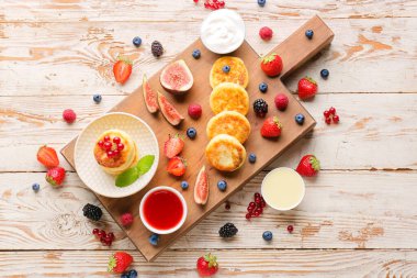 Süzme peynirli krep, böğürtlen ve açık beyaz arka planda reçel.