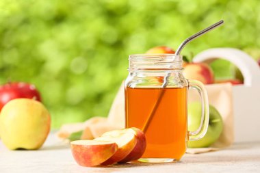 Mason kavanozu elma suyu ve açık havada taze meyveler.