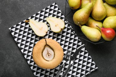 Lezzetli armut çöreği ve koyu arkaplanda taze meyveler.