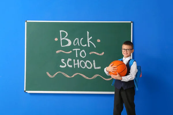 Schoolboy Med Boll Nära Svarta Tavlan Färg Bakgrund — Stockfoto