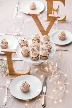 Tatlı standı, lezzetli düğün kekleri ve masada aşk sözcüğü.