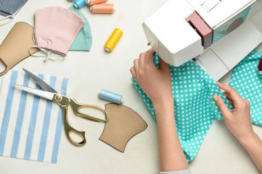 Kadın beyaz arka planda elbise dikiyor