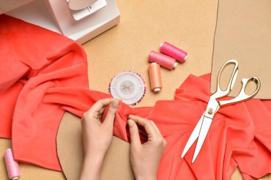 Kadın renk arkaplanda elbise dikiyor