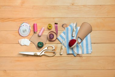 Ahşap arka planda tıbbi maske desenleri olan terzi malzemeleri.