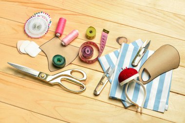 Ahşap arka planda tıbbi maske desenleri olan terzi malzemeleri.