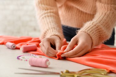 Stüdyoda kıyafet diken genç bir kadın.