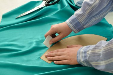 Masada kumaşla çalışan genç bir kadın.