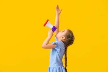 Little girl shouting into megaphone on color background clipart