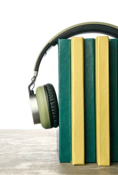 Moderne Kopfhörer Mit Büchern Auf Dem Tisch Vor Weißem Hintergrund — Stockfoto