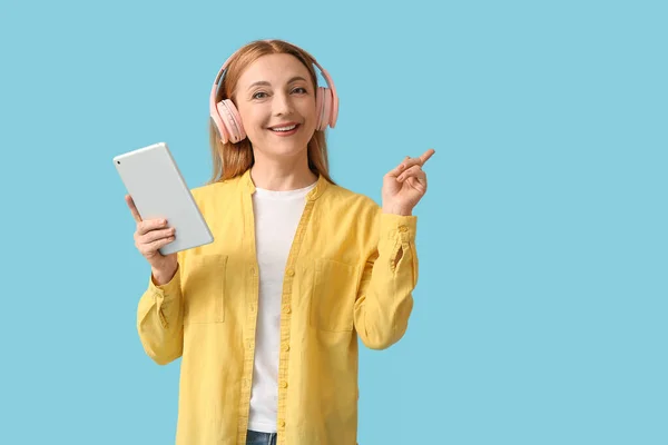 Volwassen Vrouw Met Tablet Computer Wijzend Iets Kleur Achtergrond — Stockfoto