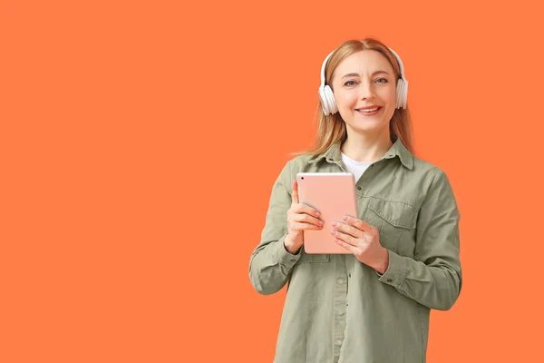 Mulher Madura Com Computador Tablet Ouvindo Audiobook Fundo Cor — Fotografia de Stock