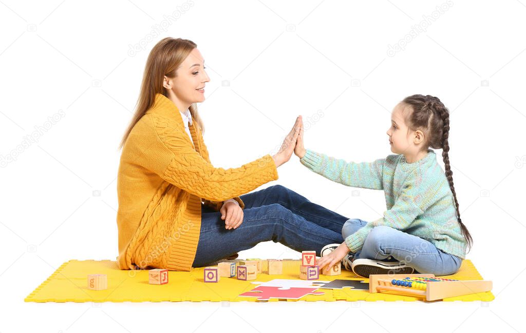 Female psychologist and girl with autistic disorder giving each other high-five on white background