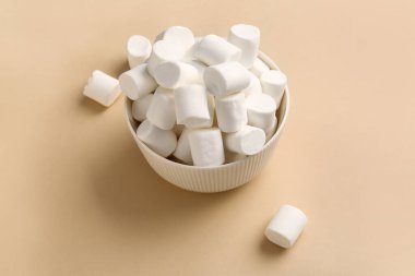 Renk arka plan üzerinde lezzetli marshmallow ile kase