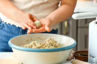Mutfaktaki masada morina pirzolası pişiren kadın, yakın plan.