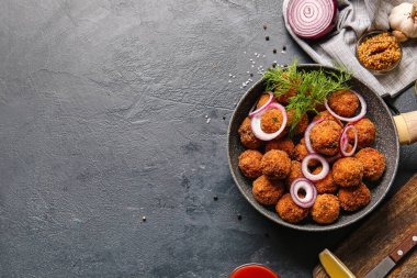 Koyu arkaplanda lezzetli morina pirzolası olan kızartma tavası.