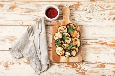 Lezzetli ızgara kabak ve ahşap arka planda domates soslu pano.