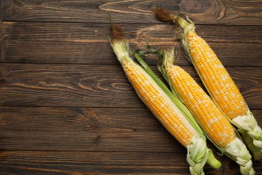 Tahta arka planda taze mısır koçanları