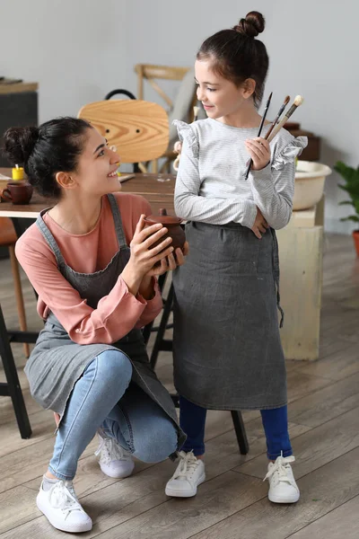 小女孩和她的母亲在家里带着刷子和瓷壶 — 图库照片