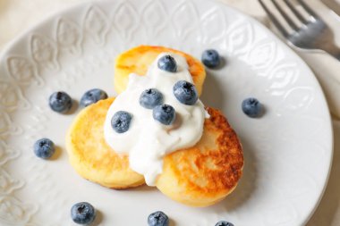 Süzme peynirli krep ve yaban mersinli tabak, yakın plan.