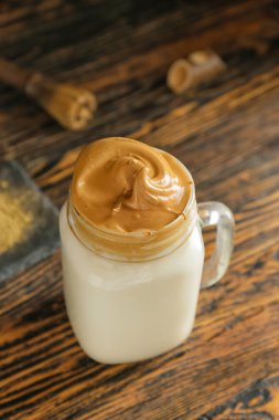 Masada bir kavanoz lezzetli dalgona hojicha latte.