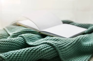 Pencerenin yanında örülmüş ekoseli kitap