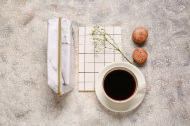 Şık bir kalem kutusu, bir fincan kahve, kurabiyeler ve grunge arkaplanda bir defter.