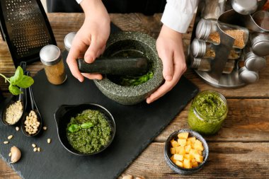 Masada lezzetli pesto sosu hazırlayan kadın.