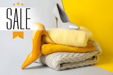 Kadın ayakkabılı şık kazaklar ve renkli arka planda kelime satışı.