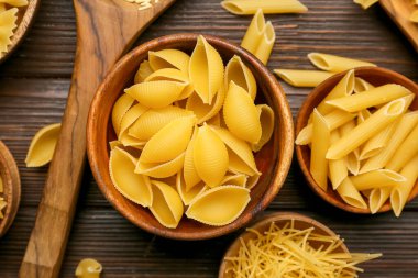 Koyu ahşap arka planda farklı türde pişmemiş makarna.