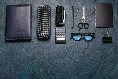 Kalem kutusu, gözlükler ve koyu arkaplan kırtasiyesi.