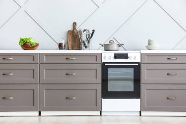 Modern mutfak tezgahı, ışık duvarının yanında fırın.