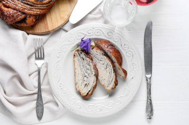 Dilimlenmiş haşhaşlı çörekler ve hafif ahşap arka plan.