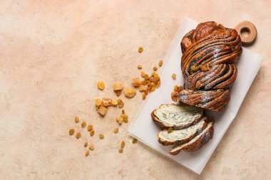 Dilimlenmiş haşhaşlı çörek, succade ve arkaplandaki üzümler